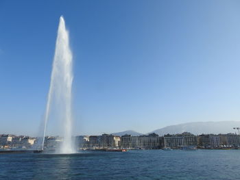 View of fountain in city against clear sky
