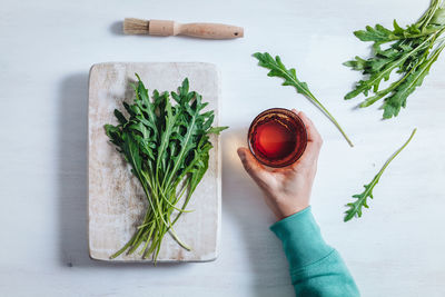 High angle view of hand holding food on cutting board