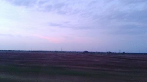 Scenic view of field against cloudy sky