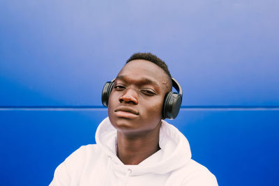 Portrait of young man against blue sky