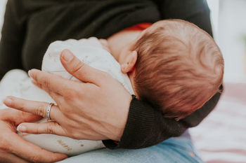 Midsection of woman breastfeeding baby