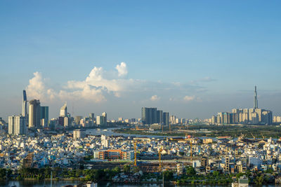 High angle view of buildings in city against cloudy sky