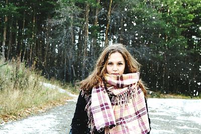Portrait of young woman standing in snow
