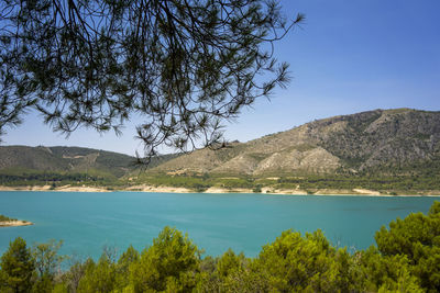 Scenic view of lake and mountains against blue sky