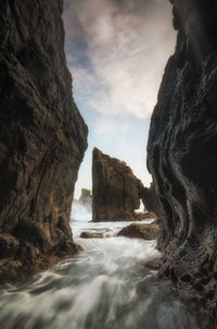 Rock formations by sea against sky