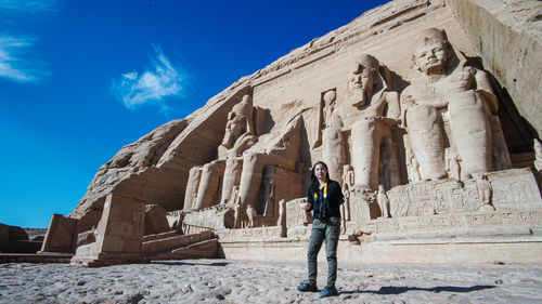 Asian tourist in front of masjestic abu simbel temple of egypt grand beautiful ancient architecture