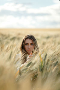 Portrait of young woman sitting on field