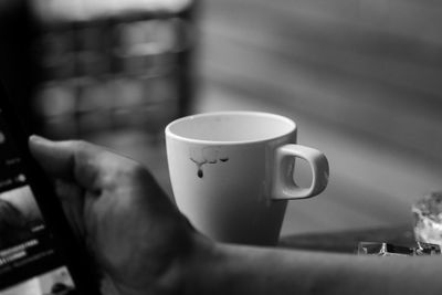 Close-up of hand holding coffee cup