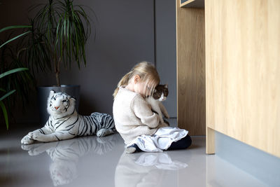 Full length of woman with toy sitting on floor at home