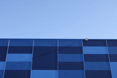 Low angle view of modern building against clear blue sky