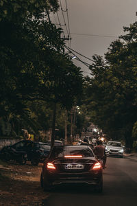 Cars on street in city against sky