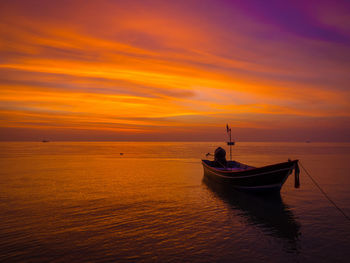 Boat in sea against orange sky