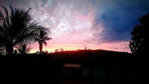 Silhouette of palm trees against sky at sunset