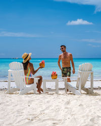 Rear view of woman sitting at beach