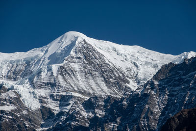 Scenic view of snowcapped mountains against clear blue sky