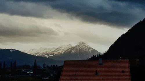 Houses on snowcapped mountains against sky