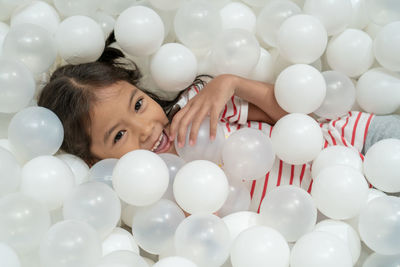 Full length portrait of smiling girl with balloons