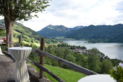 Tables by fence against lake schliersee