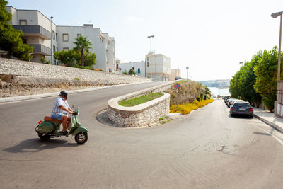 Man riding motorcycle on road in city