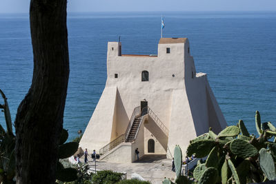 Built structure by sea against sky