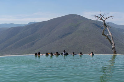 People swimming in pool against sky