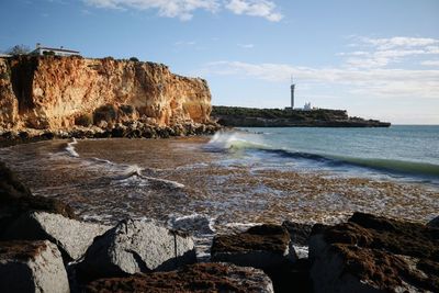 Scenic view of rocks in sea against sky