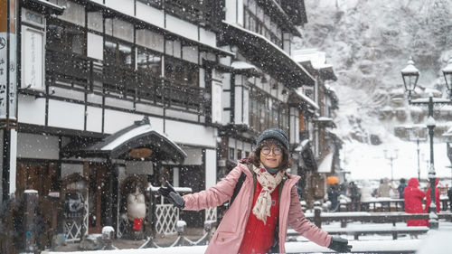 Portrait of smiling young woman standing in city