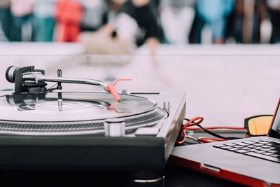 Close-up of turntable by laptop during party