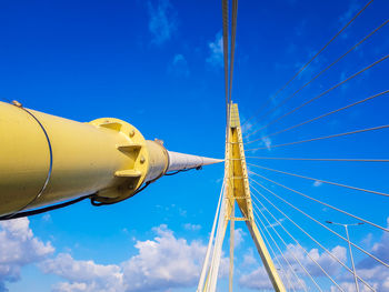 Low angle view of cross tower against blue sky