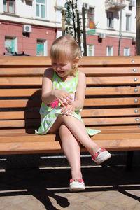 Amusing young girl laughing sitting on the bench