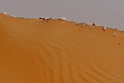 Sand dune in desert against clear sky