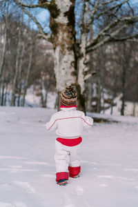 Low section of woman skiing on snow covered field