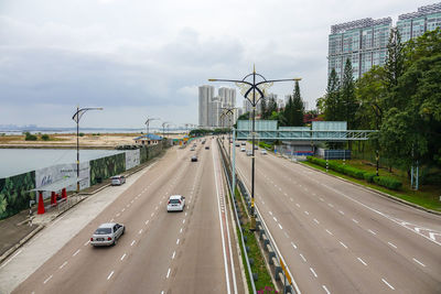 Cars on road in city against sky