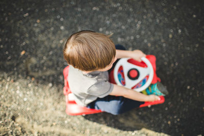 High angle view of boy sitting outdoors