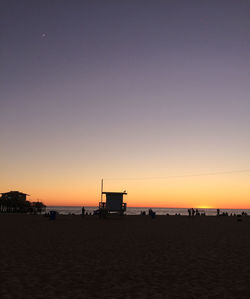 Scenic view of beach against clear sky during sunset