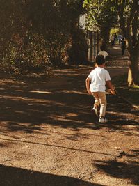 Rear view of man walking on footpath