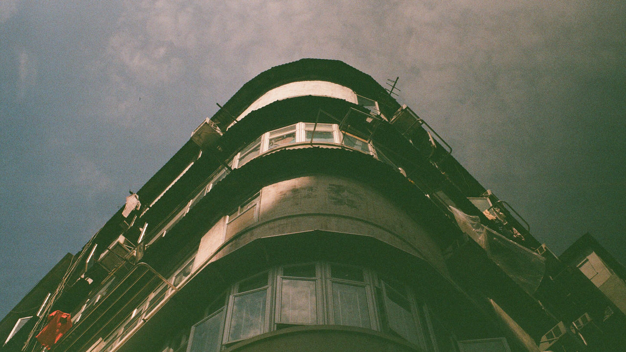 LOW ANGLE VIEW OF BUILDING AGAINST CLOUDY SKY