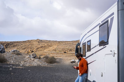 Rear view of man standing on road against sky