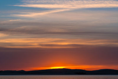 Scenic view of sea against romantic sky at sunset