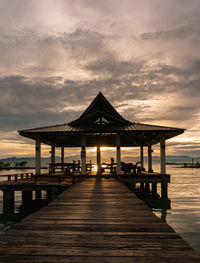 Pier over sea against sky during sunset