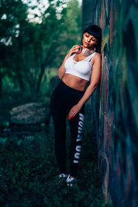 Young woman looking away while standing on land