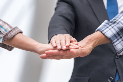 Cropped image of business people stacking hands