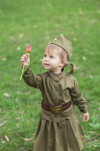 Portrait of cute girl blowing bubbles on field