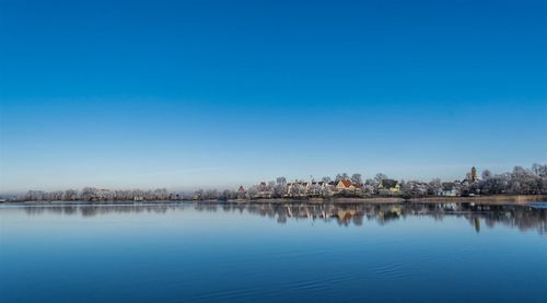 Scenic view of lake against clear blue sky