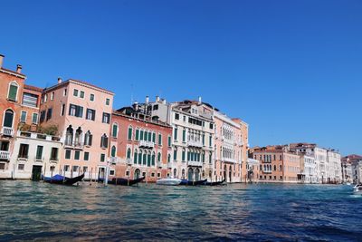 Boats in canal along buildings