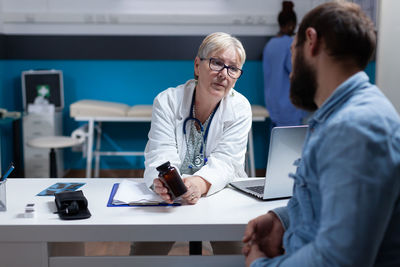 Doctor prescribing medicine to patient at clinic