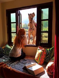 Woman with dog sitting on table at home