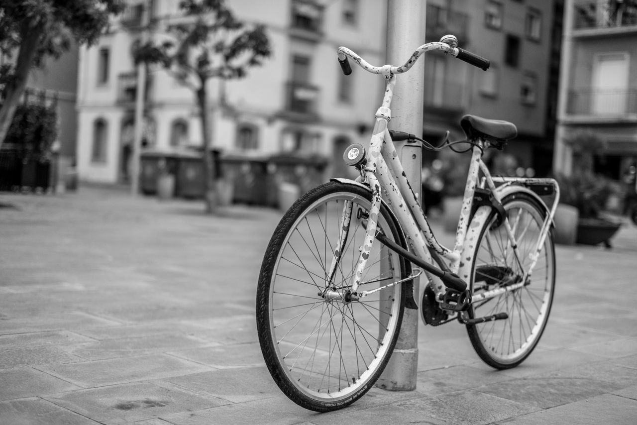 bicycle, transportation, mode of transport, land vehicle, stationary, parked, parking, street, building exterior, architecture, focus on foreground, built structure, outdoors, day, side view, riding, road, cycle, motor scooter, bicycle basket