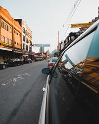 Vehicles on road against buildings in city