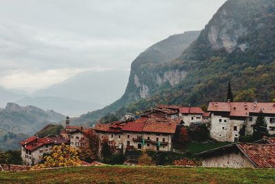 Houses on mountain against cloudy sky